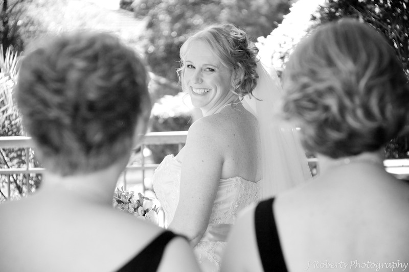 B&W bride smiling back at bridesmaids - wedding photography sydney